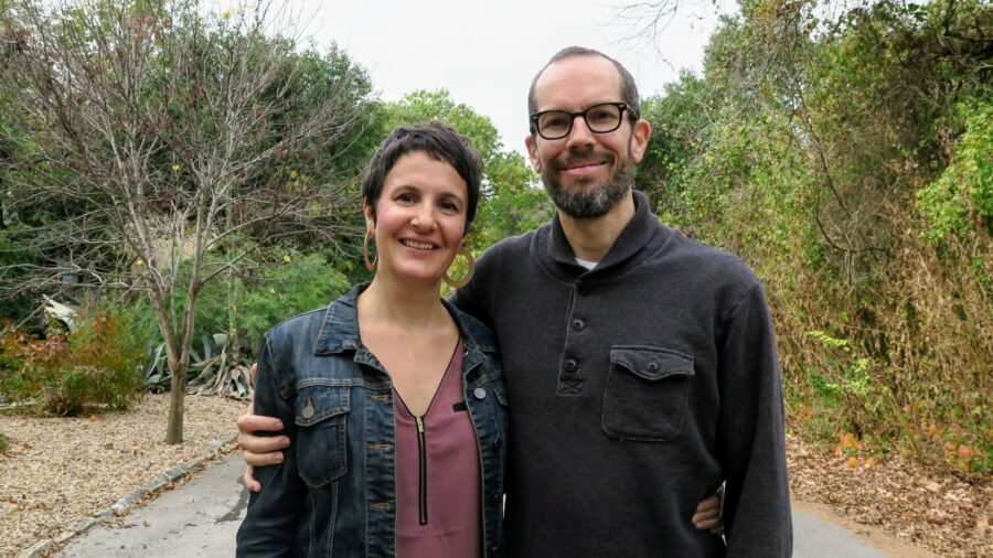 Maile and Jason, arms around each other, standing in the street, smiling